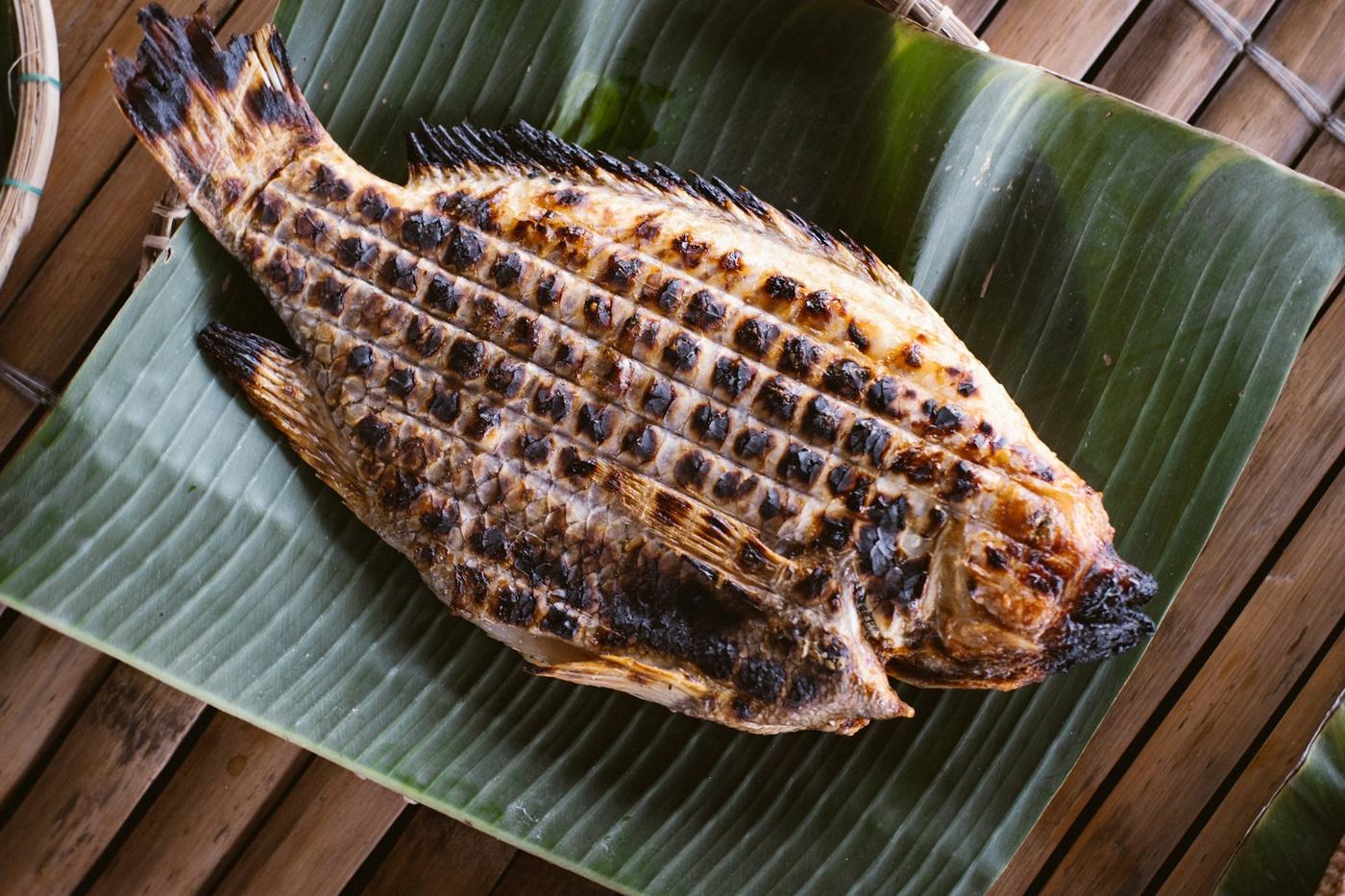 Peixe grelhado sobre folha de bananeira